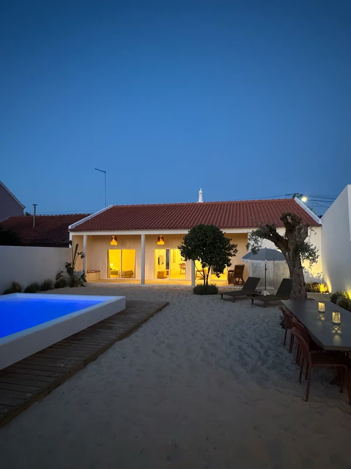 Sommarhus Beach Villa glowing beside its private pool at dusk