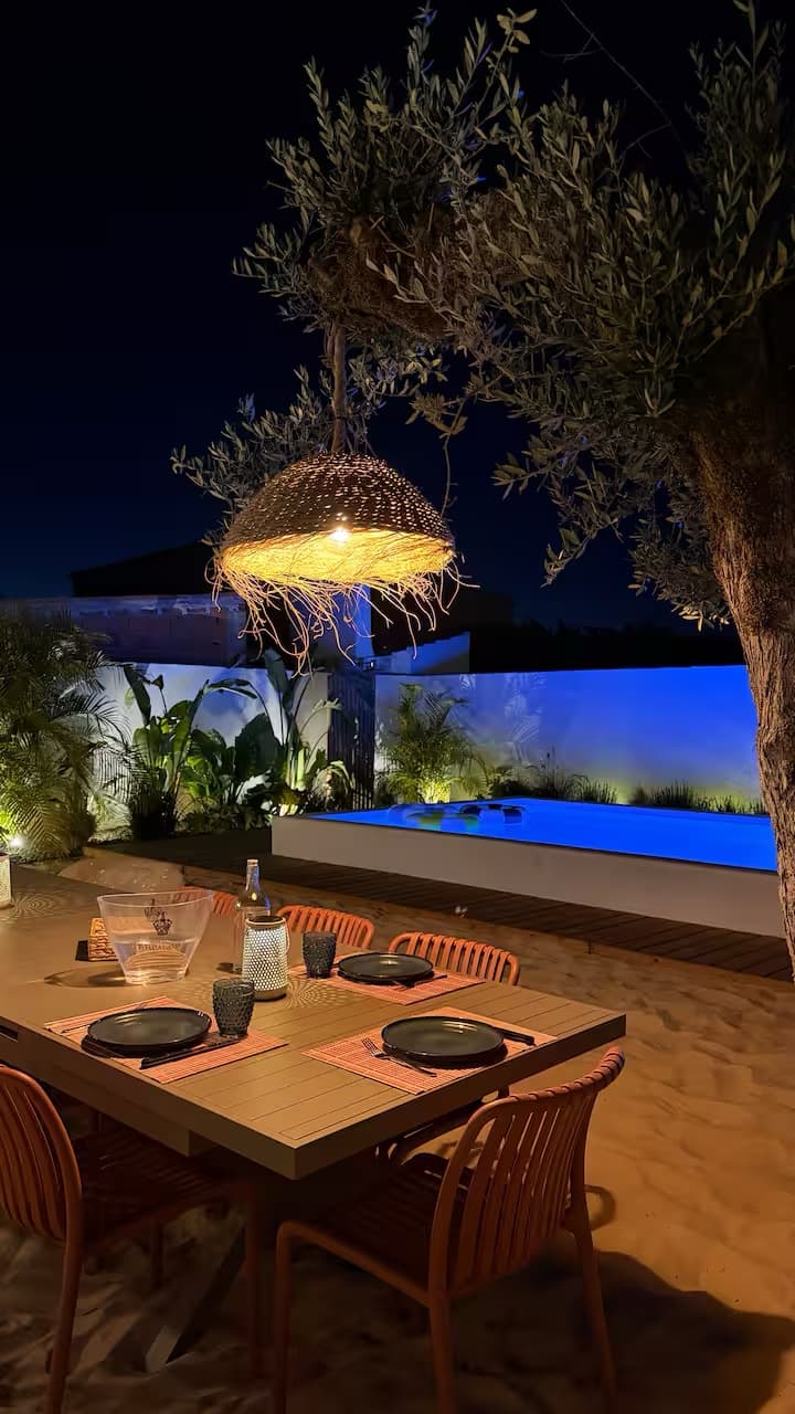 Refeição ao ar livre junto à piscina iluminada da Sommarhus Beach Villa