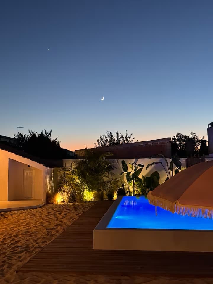 A piscina privada e o jardim tropical da Sommarhus Beach Villa ao anoitecer